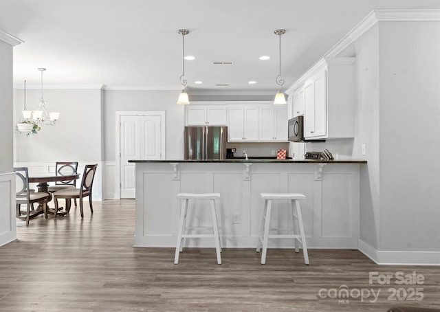 10340 Williams Rd, Mint Hill, NC 28227 - kitchen with freestanding refrigerator, black microwave, dark countertops, crown molding, and a peninsula