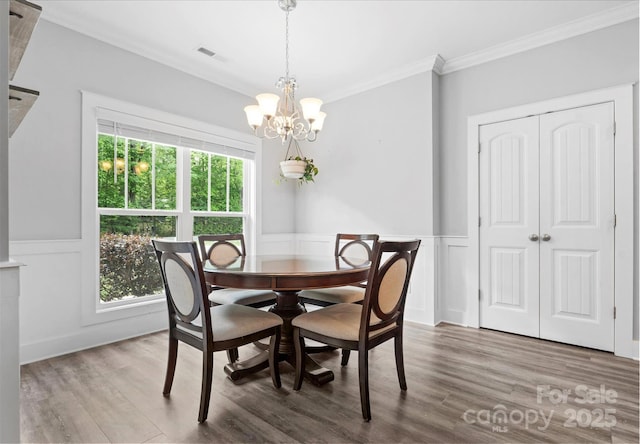 10340 Williams Rd, Mint Hill, NC 28227 - dining space with ornamental molding, a chandelier, wood finished floors, wainscoting, and a decorative wall