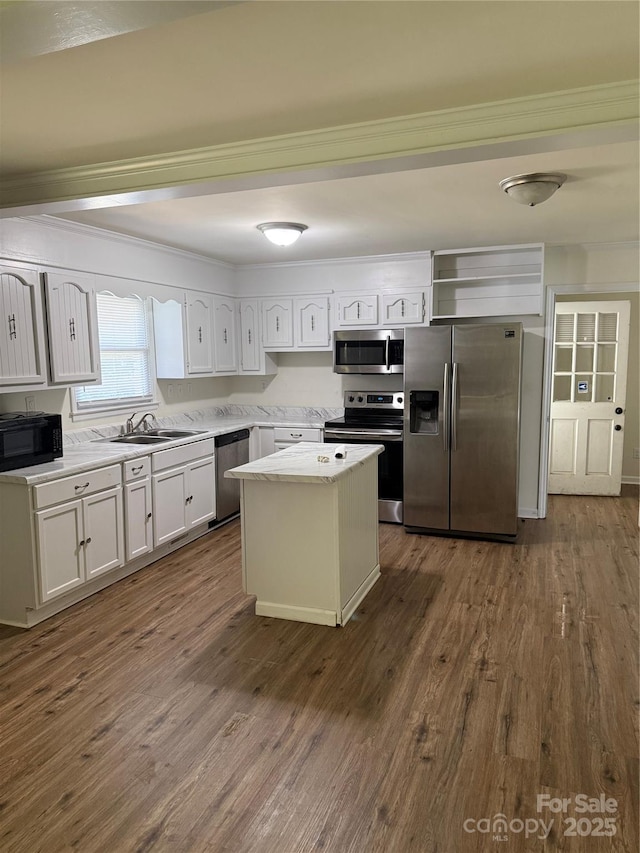 629 Belmorrow Dr, Charlotte, NC 28214 - kitchen featuring stainless steel appliances, ornamental molding, a sink, dark wood-style flooring, and a center island