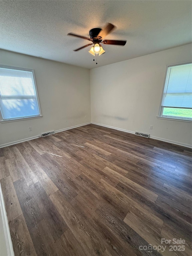 629 Belmorrow Dr, Charlotte, NC 28214 - empty room with ceiling fan, plenty of natural light, dark wood-type flooring, a textured ceiling, and baseboards