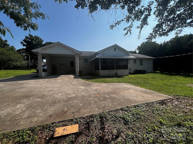 629 Belmorrow Dr, Charlotte, NC 28214 - back of house with a lawn, a sunroom, an attached carport, and driveway