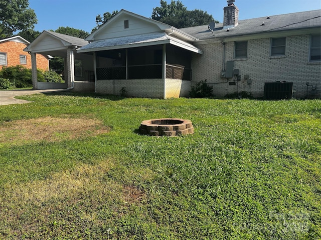 629 Belmorrow Dr, Charlotte, NC 28214 - rear view of house featuring a fire pit, a yard, brick siding, and central AC unit