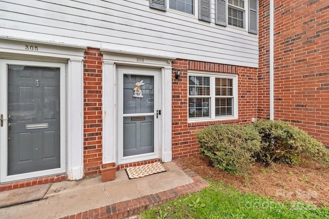 doorway to property with brick siding