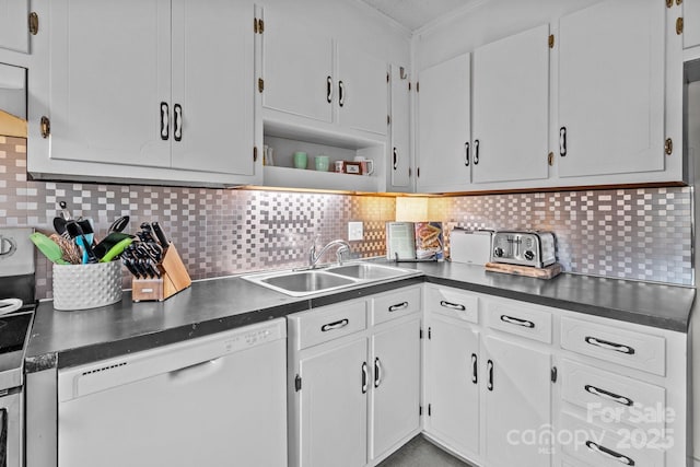 kitchen with ornamental molding, dark countertops, white cabinets, dishwasher, and a sink