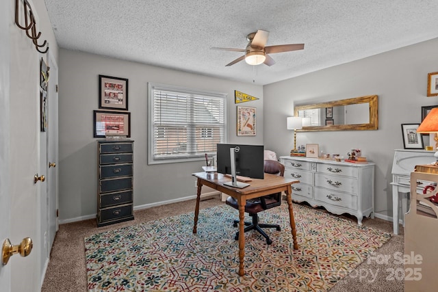 carpeted home office featuring baseboards, a textured ceiling, and a ceiling fan