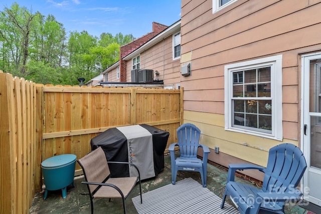 deck with a patio, central air condition unit, grilling area, and fence