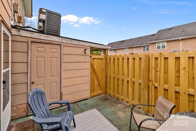 view of patio / terrace with central air condition unit and fence