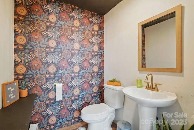 bathroom featuring curtained shower, toilet, and a sink