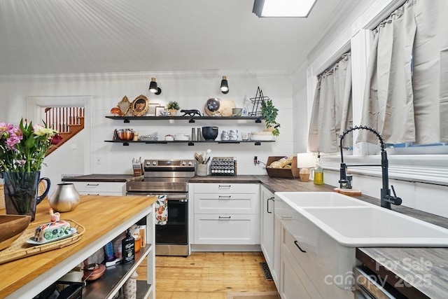 kitchen featuring open shelves, crown molding, stainless steel range with electric stovetop, and white cabinetry