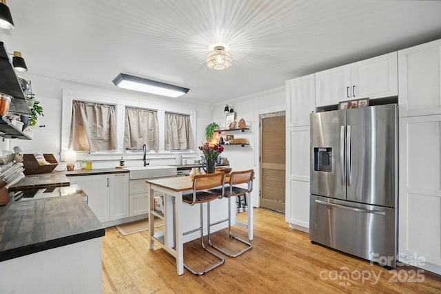 kitchen with open shelves, a sink, light wood finished floors, white cabinets, and stainless steel refrigerator with ice dispenser