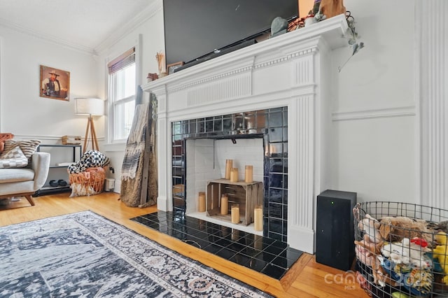 living area with ornamental molding and wood finished floors