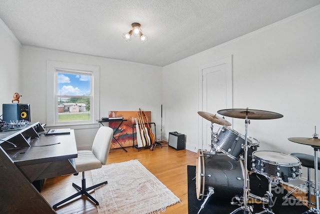 home office with baseboards, crown molding, wood finished floors, and a textured ceiling