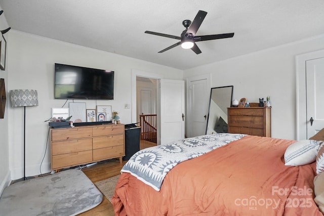 bedroom featuring crown molding, ceiling fan, and wood finished floors