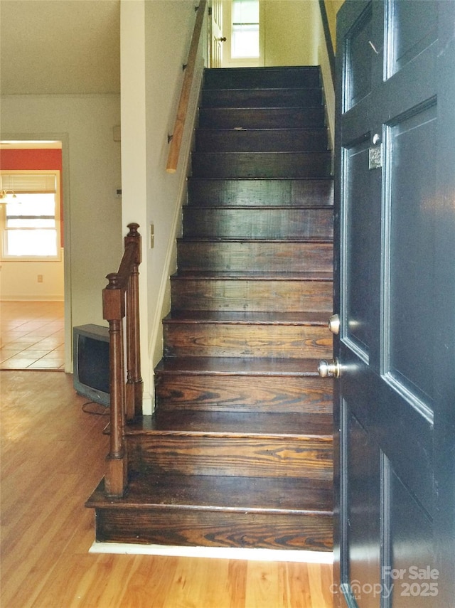 stairway with baseboards and wood finished floors