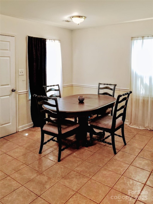 dining area featuring visible vents and light tile patterned floors
