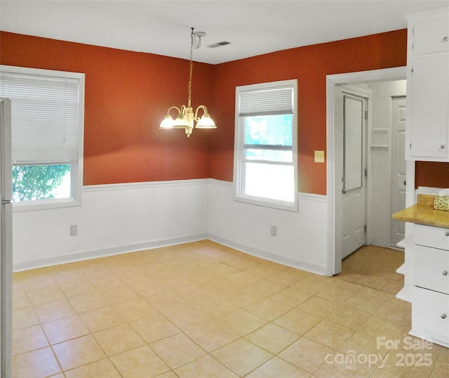 unfurnished dining area with visible vents and an inviting chandelier