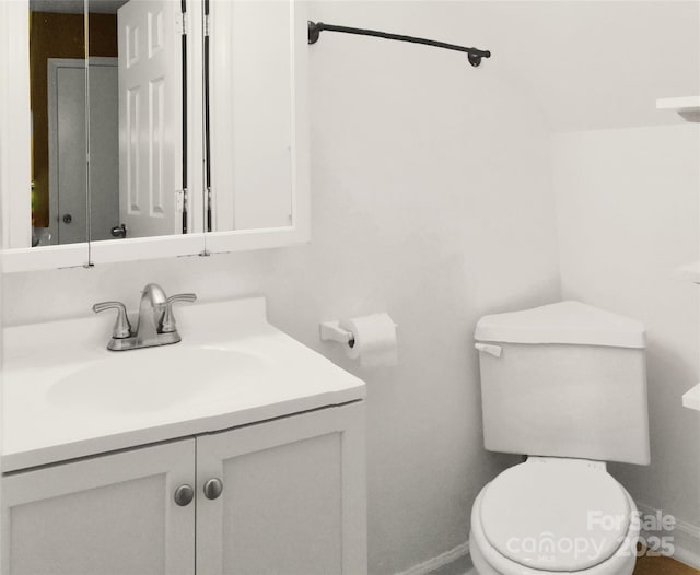 bathroom with toilet, baseboards, and vanity
