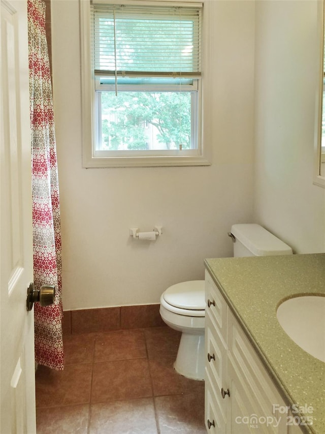 bathroom featuring toilet, tile patterned floors, a wealth of natural light, and vanity