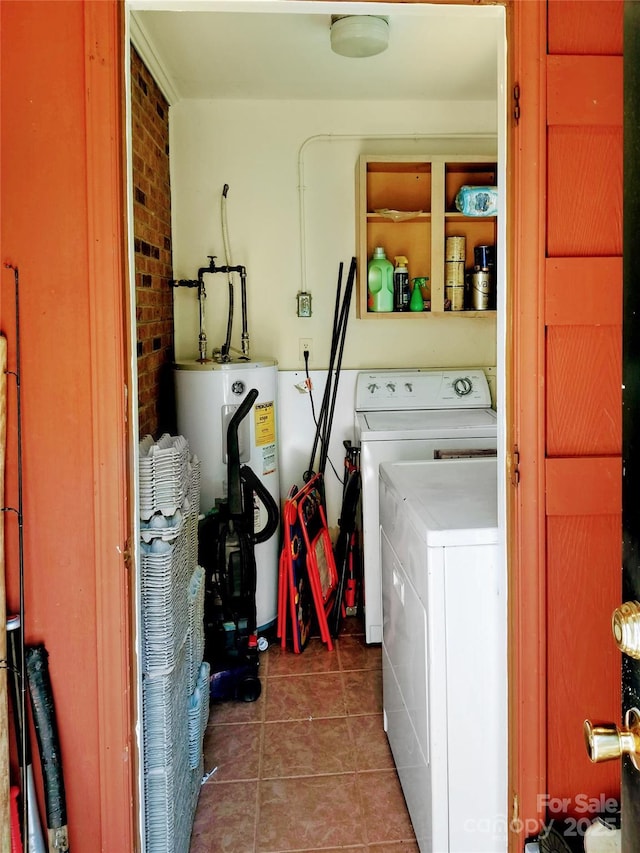 laundry area with laundry area, brick wall, washing machine and dryer, tile patterned floors, and water heater