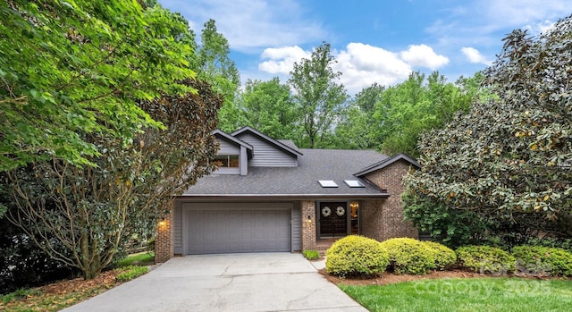 view of front of house featuring brick siding, a shingled roof, an attached garage, and concrete driveway