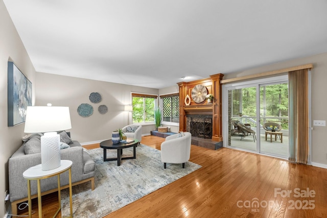 living room with baseboards, a fireplace, and hardwood / wood-style floors