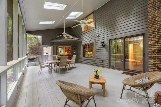sunroom / solarium with outdoor dining space, ceiling fan, and a skylight
