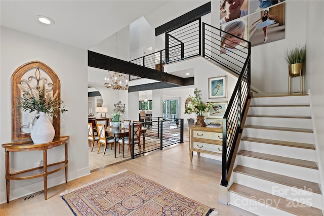 4039 5th St NW, Hickory, NC 28601 - stairs featuring wood finished floors, arched walkways, a chandelier, and baseboards