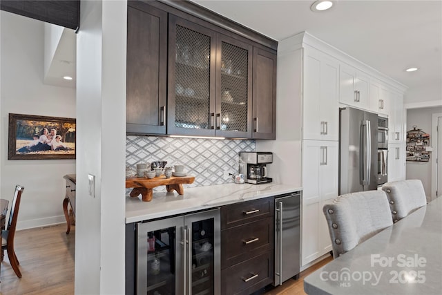 4039 5th St NW, Hickory, NC 28601 - bar area with beverage cooler, appliances with stainless steel finishes, tasteful backsplash, light wood-type flooring, and recessed lighting