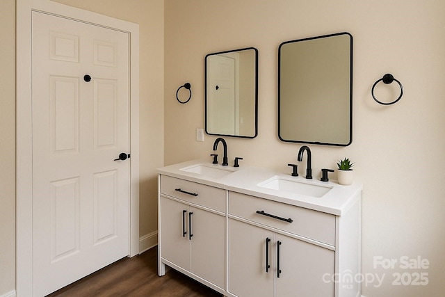 bathroom featuring wood finished floors, double vanity, and a sink