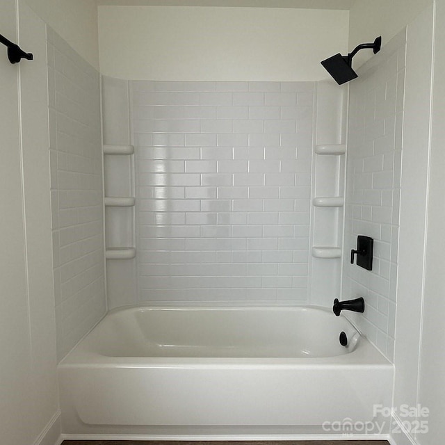 bathroom featuring baseboards and  shower combination