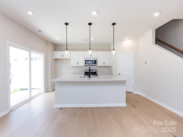 2021 Endeavor Run, Charlotte, NC 28269 - kitchen featuring stainless steel appliances, white cabinetry, tasteful backsplash, light wood-style floors, and recessed lighting