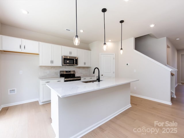 2021 Endeavor Run, Charlotte, NC 28269 - kitchen featuring appliances with stainless steel finishes, a sink, light wood-type flooring, white cabinetry, and recessed lighting