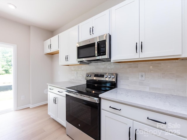 2021 Endeavor Run, Charlotte, NC 28269 - kitchen featuring stainless steel appliances, light wood-type flooring, baseboards, light stone countertops, and decorative backsplash