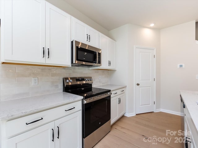2021 Endeavor Run, Charlotte, NC 28269 - kitchen with stainless steel appliances, tasteful backsplash, light wood-type flooring, white cabinetry, and baseboards