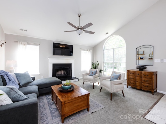 7731 Ivy Hollow Dr, Charlotte, NC 28227 - tiled living room with lofted ceiling, a ceiling fan, a fireplace with raised hearth, and visible vents
