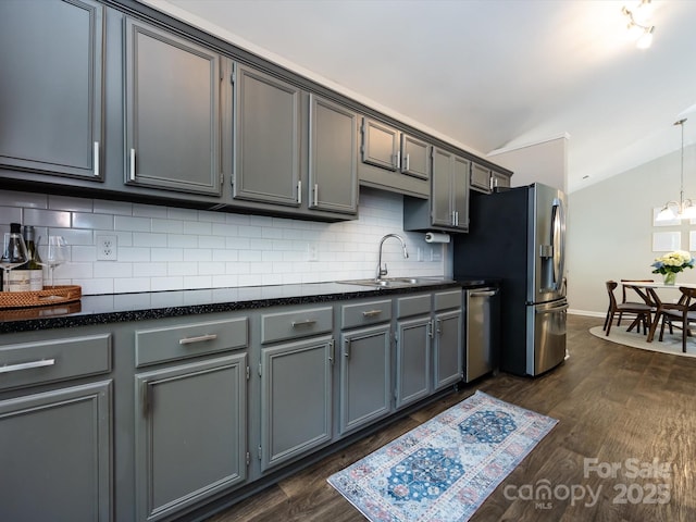7731 Ivy Hollow Dr, Charlotte, NC 28227 - kitchen featuring vaulted ceiling, a sink, stainless steel appliances, backsplash, and gray cabinetry