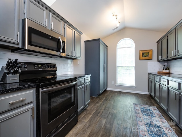 7731 Ivy Hollow Dr, Charlotte, NC 28227 - kitchen with dark stone counters, vaulted ceiling, range with electric stovetop, stainless steel microwave, and dark wood-style flooring