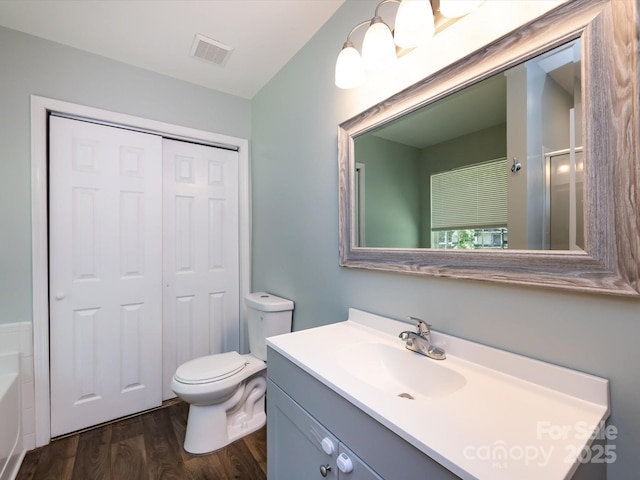 7731 Ivy Hollow Dr, Charlotte, NC 28227 - bathroom featuring wood finished floors, vanity, a bathtub, toilet, and visible vents