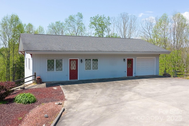 single story home with an outdoor structure, a garage, and concrete driveway