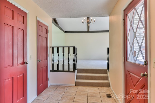 foyer featuring a healthy amount of sunlight, light tile patterned flooring, a notable chandelier, and visible vents