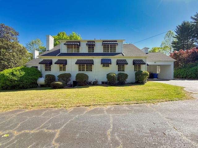559 N Washington St, Rutherfordton, NC 28139 - view of front of house featuring a chimney, aphalt driveway, a carport, roof with shingles, and a front yard