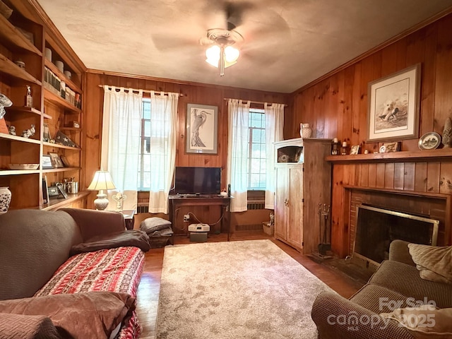 559 N Washington St, Rutherfordton, NC 28139 - living room featuring ceiling fan, wood walls, a brick fireplace, and wood finished floors