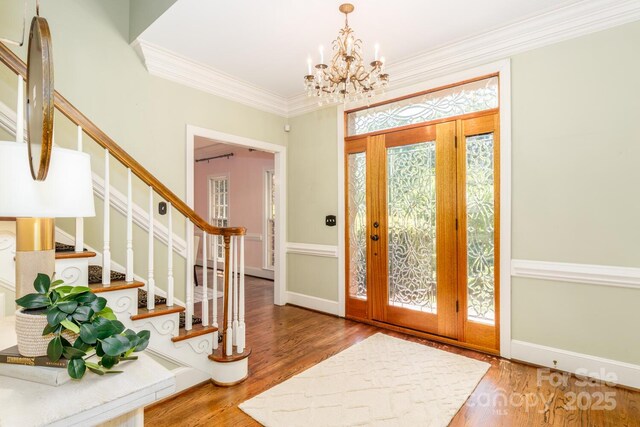 1233 Weymouth Ln, Charlotte, NC 28270 - foyer with crown molding, a notable chandelier, baseboards, wood finished floors, and stairway
