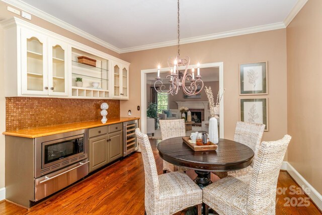 1233 Weymouth Ln, Charlotte, NC 28270 - dining area featuring ornamental molding, beverage cooler, baseboards, dark wood-style floors, and a chandelier