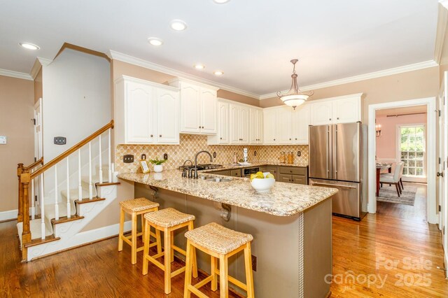 1233 Weymouth Ln, Charlotte, NC 28270 - kitchen with a peninsula, ornamental molding, high end refrigerator, and light wood-style floors