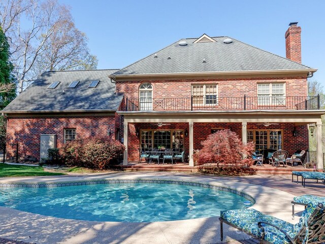 1233 Weymouth Ln, Charlotte, NC 28270 - rear view of property featuring brick siding, a patio area, a balcony, and a chimney