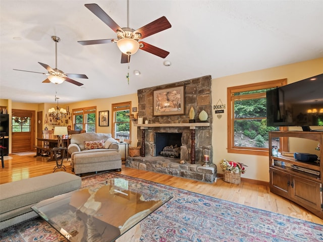 218 Red Oak Dr, Maggie Valley, NC 28751 - living area with light wood-type flooring, lofted ceiling, a ceiling fan, a stone fireplace, and a chandelier