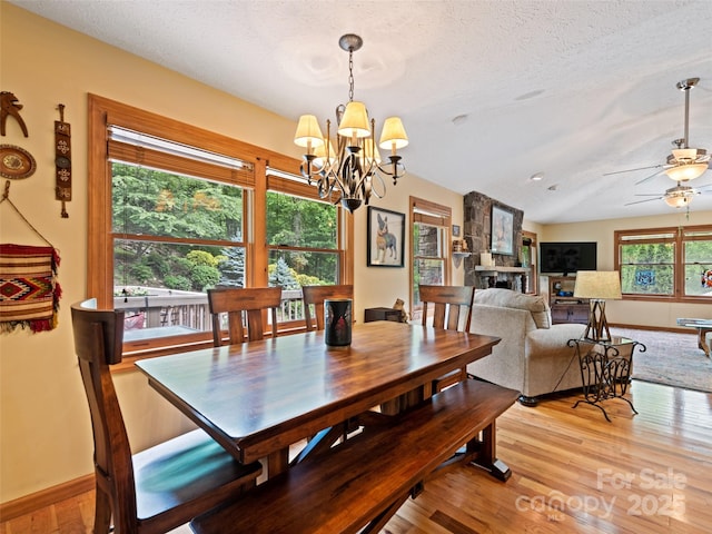 218 Red Oak Dr, Maggie Valley, NC 28751 - dining area featuring a chandelier, light wood-style floors, a ceiling fan, a textured ceiling, and baseboards