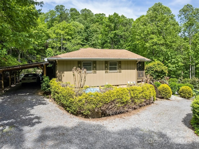 218 Red Oak Dr, Maggie Valley, NC 28751 - view of home's exterior featuring a carport, asphalt driveway, a view of trees, and roof with shingles