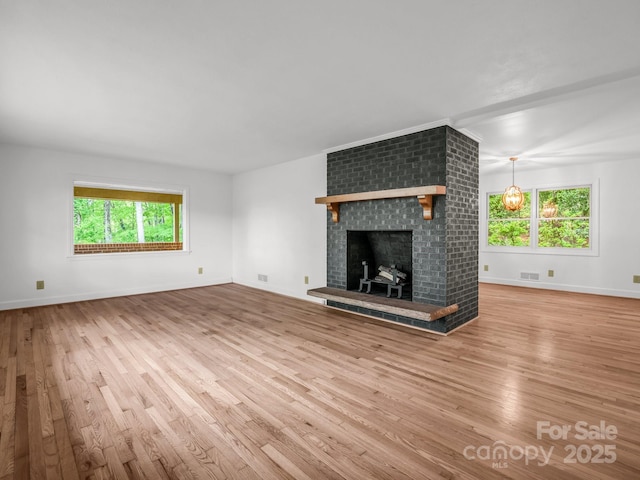 unfurnished living room featuring wood finished floors and healthy amount of natural light